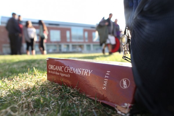 Closeup of a textbook lying on the grass outside the Student Union